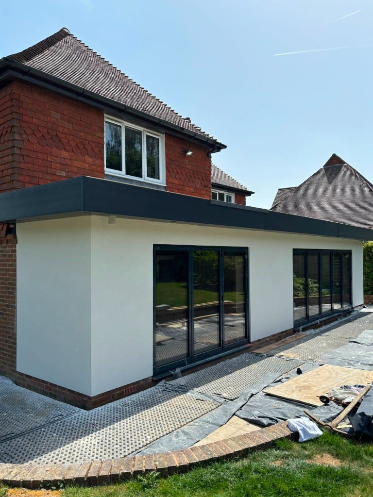 Rendered single-storey extension with bifold doors on a brick house in Kent