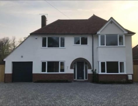 Detached house finished in white monocouche render with a tiled roof in Kent