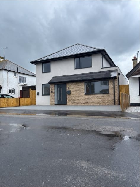 Newly rendered detached new-build house with brick plinth in Kent