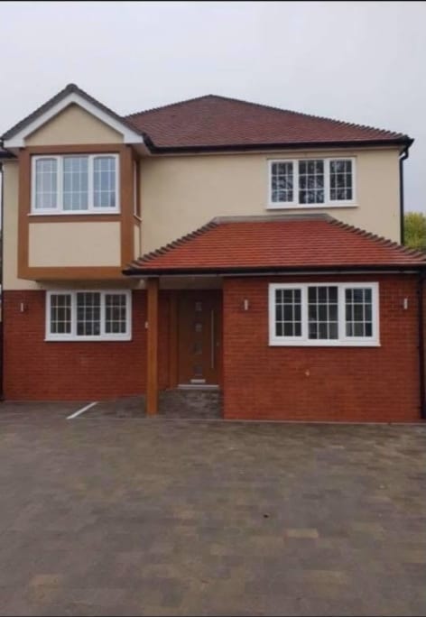 Large detached house with cream render and red brick in Kent